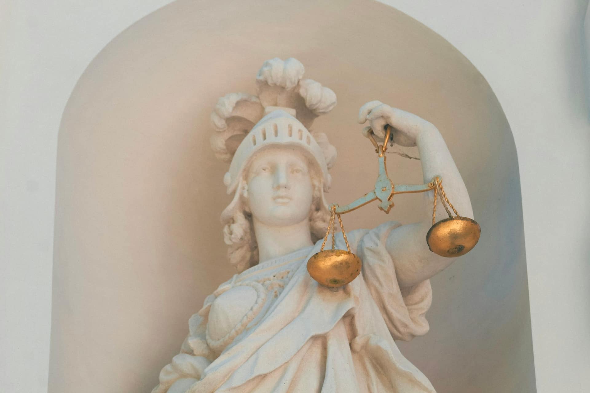 A white marble statue holding golden scales